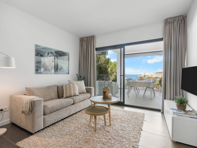 Living room with a sofa, a television and sliding doors onto the terrace