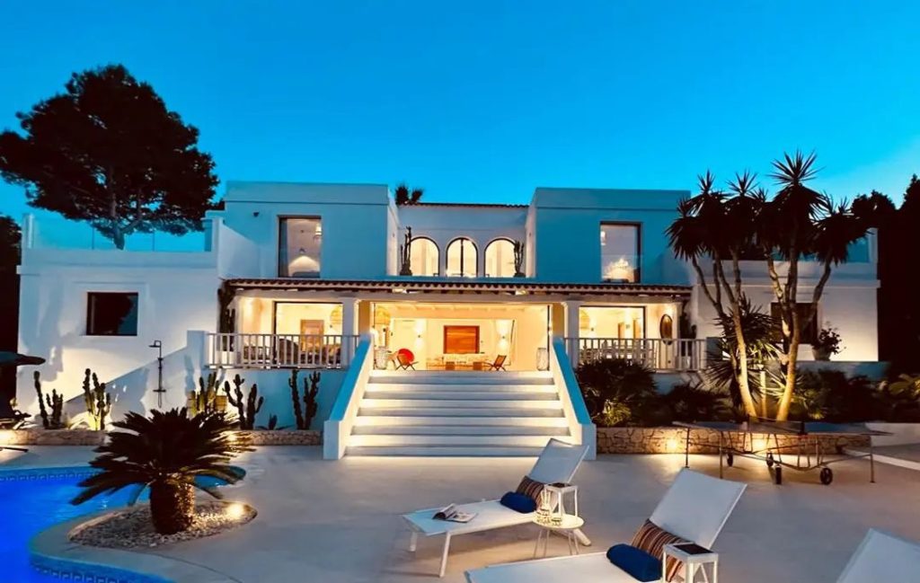 La piscina iluminada de una villa en Ibiza al anochecer