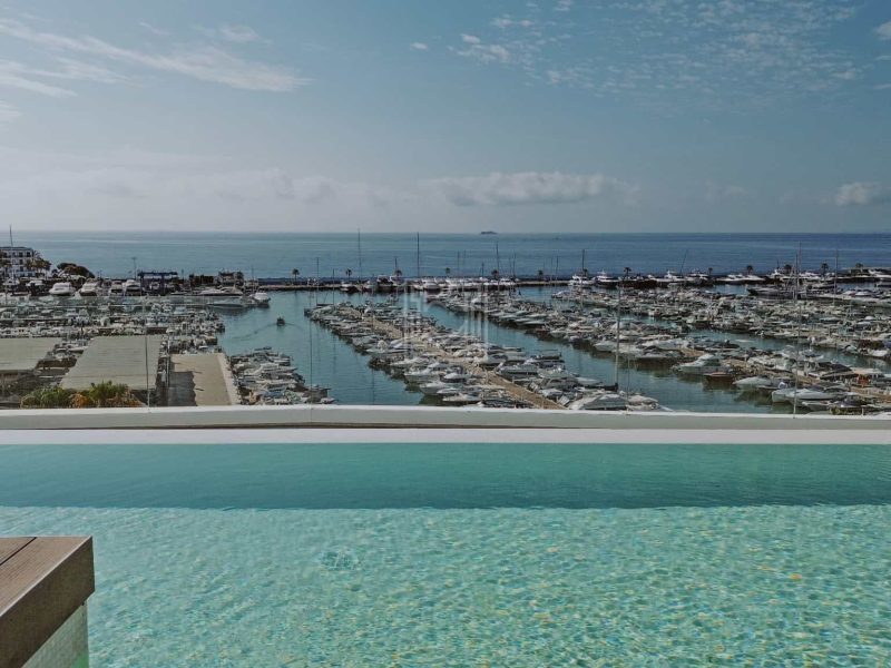 Communal rooftop infinity pool overlooking Santa Eulària marina and the Mediterranean