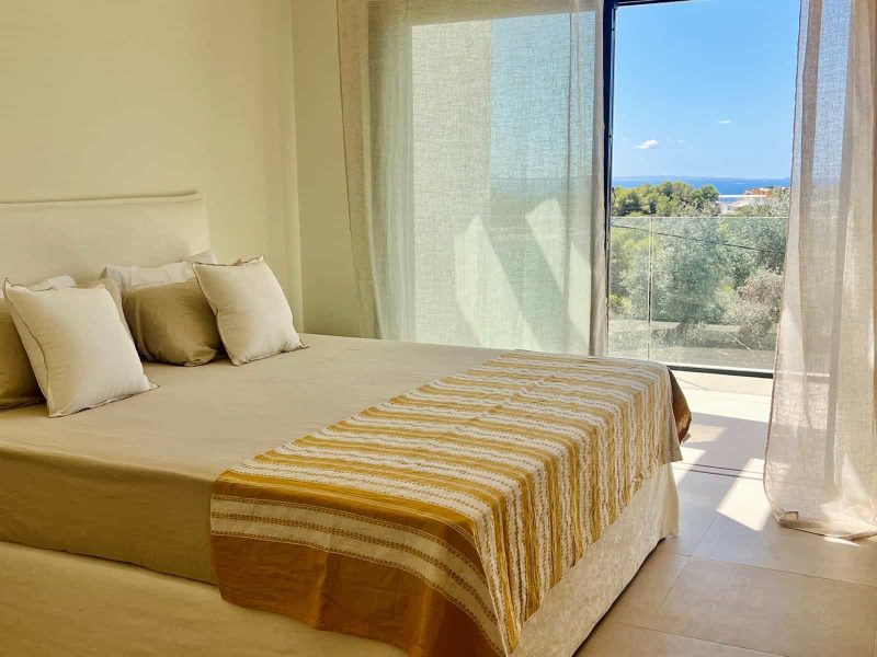 Bedroom with a floor to ceiling window looking towards the sea