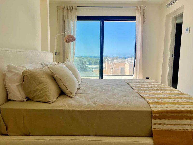 Bedroom with sliding doors onto a terrace and a view over the rooftops