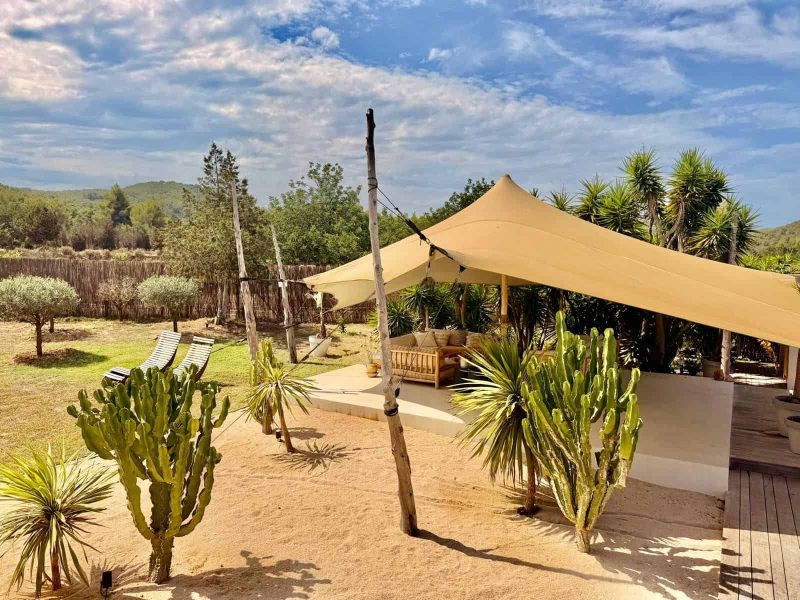 Landscaped outdoor grounds with covered lounge area near Cala Bassa