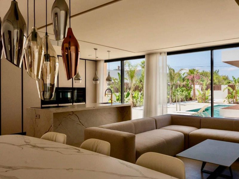 Living room with a sculptural pendant cluster and glass doors onto the garden